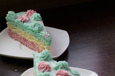 Parça kesilir ve bir daire üzerinde yan yana yatıyor. Krem yapılan gözleme pasta kek batırılmış. Krem çiçeklerle süslenmiş.