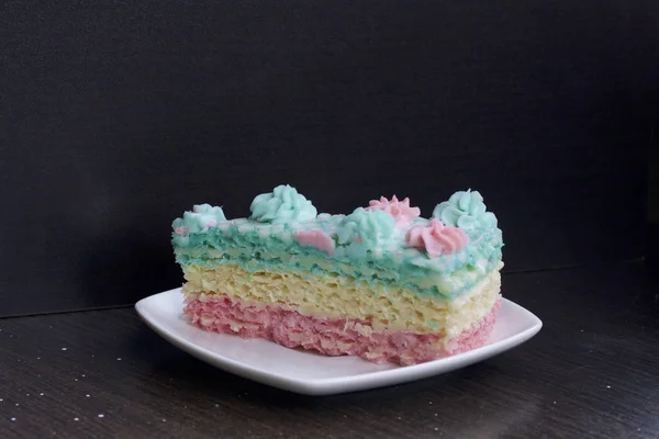 Το κομμάτι είναι αποκομμένοι και βρίσκεται πλάι-πλάι σε ένα πιατάκι. Βάφλες κέικ φτιαγμένο από κρέμα εμποτισμένο κέικ. Διακοσμημένο με λουλούδια κρέμα. — Φωτογραφία Αρχείου