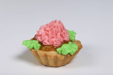 Sepet kek farklı renkteki krema ile dekore edilmiştir. Reçel doldurma. Beyaz bir arka plan üzerinde.