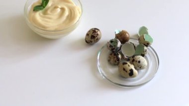 Pişirme mayonez. Bir kadın mayonez yeşillikleri ile süsle. Yakınlarda bıldırcın yumurtası bulunmaktadır.