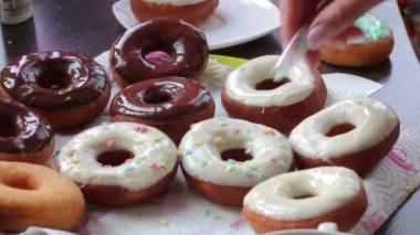 Bir kadın eritilmiş çikolata ayçiçeği yağda kızartılmış Amerikan donut dips.