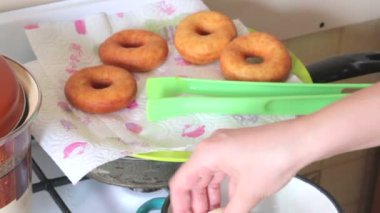 Bir kadın Amerikan donut yemek pişiriyor. Onları ayçiçek yağı fırında. Yakın donuts pişer.