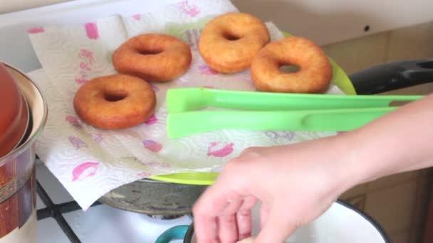 一个女人正在煮美国甜甜圈 用葵花籽油烤 附近是煮熟的甜甜圈 — 图库视频影像