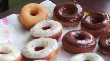 Amerikan donut, eritilmiş çikolata ile sırlı ve yağmurlama ile dekore edilmiş bir tepside yalan.