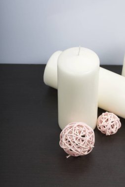 Beyaz renkte dokuma doğal malzemelerden dekoratif topları arasında mumlar.