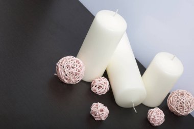 Beyaz renkte dokuma doğal malzemelerden dekoratif topları arasında mumlar.