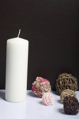 Beyaz renkte dokuma doğal malzemelerden dekoratif topları arasında mum. Beyaz bir arka plan üzerinde.
