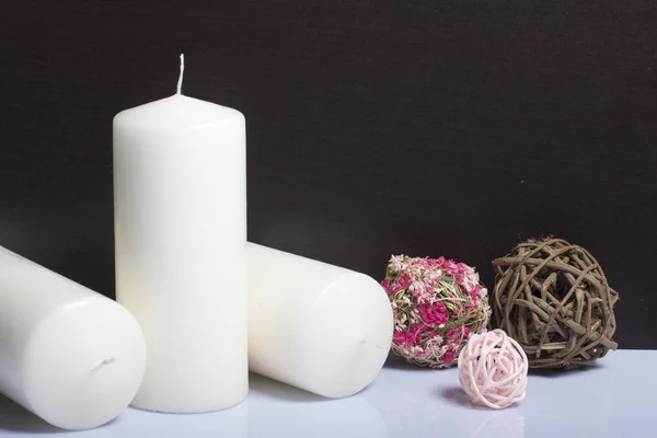 Candles white in color among the decorative balls, woven from natural materials. — Stock Photo, Image