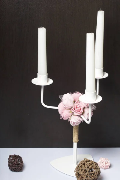 Velas blancas en un candelero de metal. Muy cerca se encuentran las bolas decorativas, tejidas con materiales naturales. Bolas de vid y hierba . — Foto de Stock