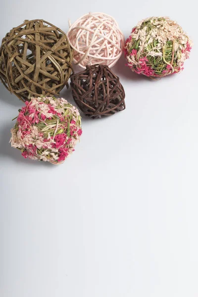 Vela de color blanco entre las bolas decorativas, tejida con materiales naturales. Sobre un fondo blanco . — Foto de Stock