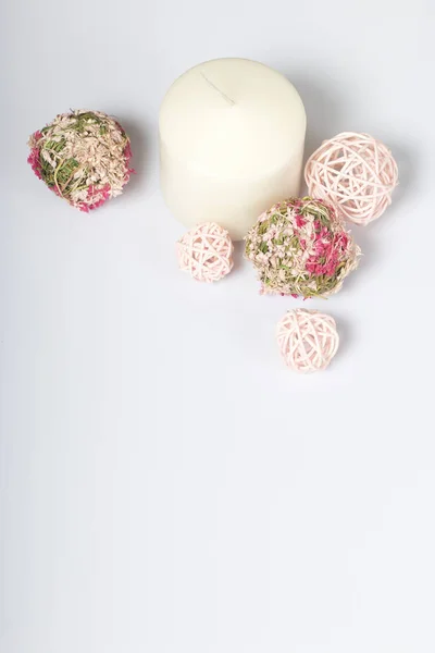 Vela de cor branca entre as bolas decorativas, tecida a partir de materiais naturais. Em um fundo branco . — Fotografia de Stock
