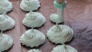 Bir kadın bir hamur işi çanta kullanarak lokum oluşturur. Kamera isabet.