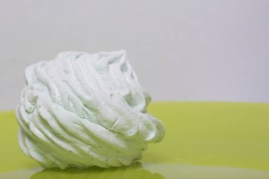 Ev yapımı krema bir tabağa koydu. Marshmallow ile nane, yeşil bir renk tonu ile. Yakın hatmi bir parçası olduğunu, kendi dilim görünürdür. Açık yeşil arka planı üzerinde.