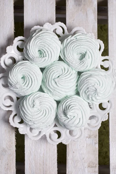 Marshmallow buatan sendiri diletakkan di atas piring. Marshmallow dengan mint, dengan warna hijau. Di latar belakang papan kayu . — Stok Foto