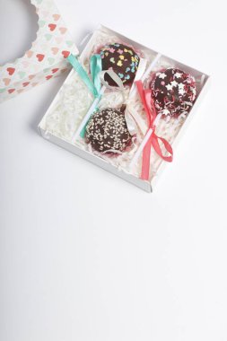 Pasta çıkar güzel bir hediye kutusunda paketlenmiştir. Yakınlarda bir saydam pencere ile bir kapak var. Beyaz bir arka plan üzerinde.