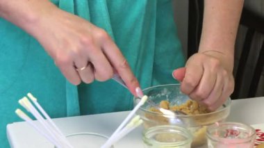 Bir kadın pasta pop bisküvi topları alır. Tablo buzlanma ile bardaklar ve topları bir plaka üzerinde tamamlandı.