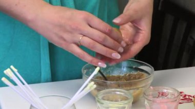 Bir kadın pasta pop bisküvi topları alır. Tablo buzlanma, sopa ve bir plaka üzerinde hazır topları ile bardaklar.