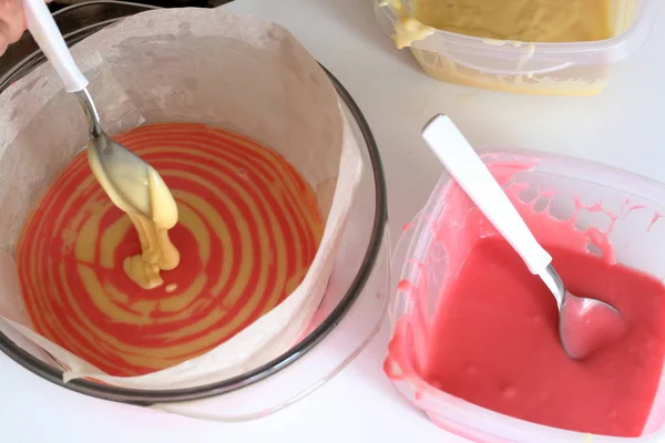 Žena se mísí těsto různých barev ve tvaru. Vaření dort s vrstvami různých barev. — Stock fotografie