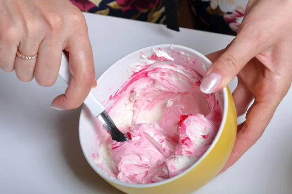 Una mujer mezcla una crema con colorante de alimentos. Crema para decorar el pastel con capas de diferentes colores . — Foto de Stock