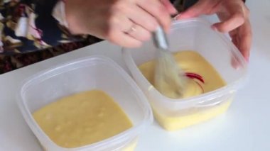 Bir kadın boya bir damla meyilli ve karışımları ekler.