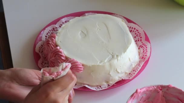 Kobieta Zdobi Różowym Kremem Stronie Powierzchni Ciasta Pomocą Worka Ciasta — Wideo stockowe