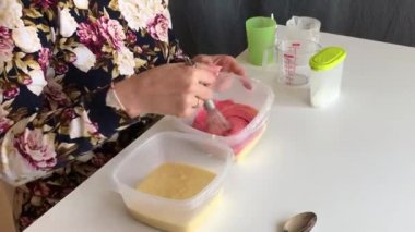 Bir kadın boya bir damla meyilli ve karışımları ekler.