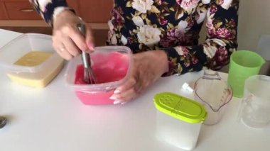 Bir kadın boya bir damla meyilli ve karışımları ekler.