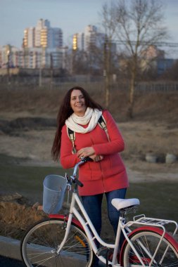 Kız Park edilmiş bir bisikletin üzerine eğilir. Bahar döngüsünde istirahat.