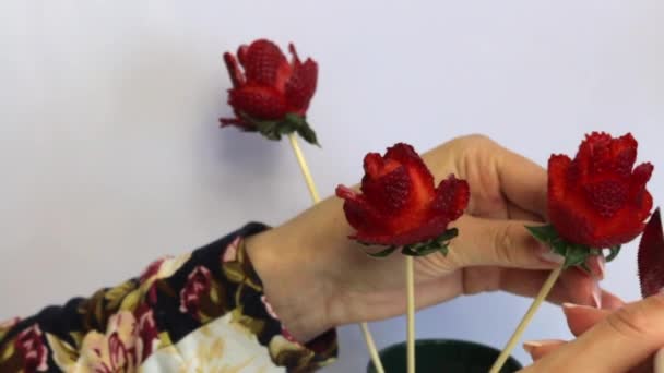 女性がイチゴからバラを作る イチゴは杖に身を包み 女性はナイフで花びらを切る これは 完成したバラの花びらを修正します — ストック動画