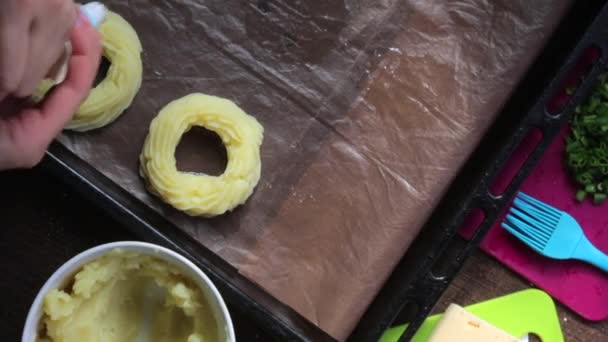 一个女人在烤盘上形成土豆泥环 在糕点袋的帮助下 旁边的其他食材烹饪晚餐 — 图库视频影像