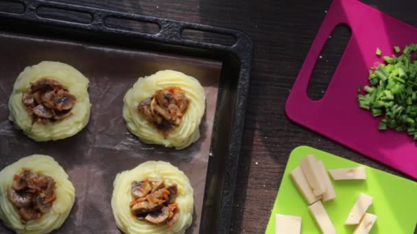 一个女人穿上蘑菇 装上奶酪 土豆泥的戒指 躺在烤盘上 旁边的其他食材烹饪晚餐 — 图库视频影像