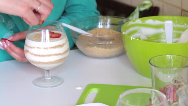 女人用草莓片装饰甜点 在玻璃层铺饼干屑和奶油 从上面的装饰从草莓 — 图库视频影像