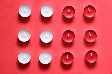 Bir satırda düzenlenmiş Dekoratif mumlar. Pembe bir arka planda.