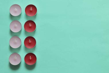 Bir satırda düzenlenmiş Dekoratif mumlar. Nane arka planda.