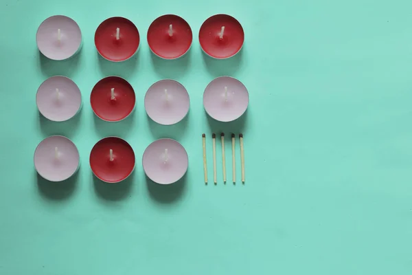 Decoratieve kaarsen en lucifers zijn gerangschikt op een rij. Op een Mint achtergrond. — Stockfoto