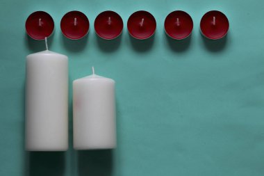 Bir satırda düzenlenmiş Dekoratif mumlar. Nane arka planda.