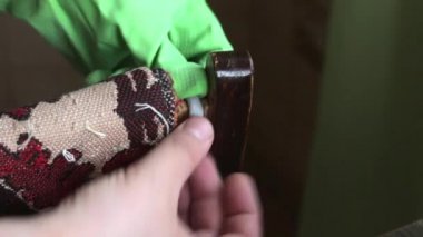 Bir adam sandalyeyi onarmak için iki bileşenli epoksi tutkal hazırlar. Yapıştırıcıyı yapıştırMa yerine koyar ve parçaları sıkıca bastırır. Bıçakla fazla klipsler. Soğuk kaynak teknolojisi.