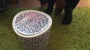 Bir işadamı çöp kutusuna buruşmuş plastik şişeler atıyor, yerde duruyor.