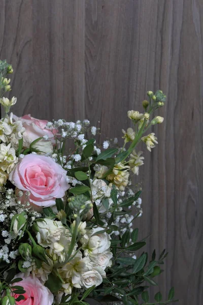 A large bouquet of different flowers. Several types of roses and other plants to decorate the bouquet.