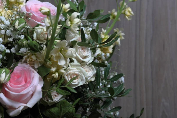 A large bouquet of different flowers. Several types of roses and other plants to decorate the bouquet.