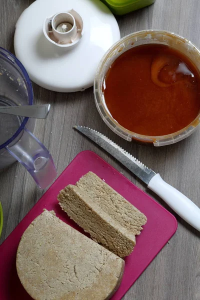 Skivad halva från honung, jordnötter och solrosfrön. Nästa honung i behållaren. Ingredienser och verktyg för att göra halva. — Stockfoto