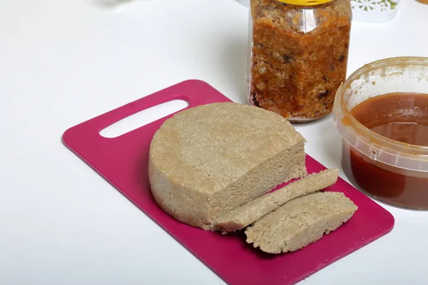 Halva en rodajas de miel, cacahuetes y semillas de girasol. Cerca de la miel en diferentes contenedores. Ingredientes y herramientas para hacer halva . —  Fotos de Stock