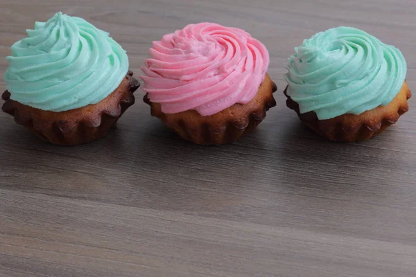 Tres pasteles de crema de diferentes colores. Párate en fila . — Foto de Stock