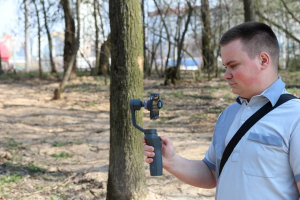 Un jeune homme filmant sur un smartphone. Utilise la carabine pour obtenir des images lisses. Regardez de près le tournage du film . — Photo