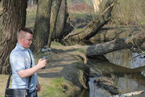 Un jeune homme filmant sur un smartphone. Utilise la carabine pour obtenir des images lisses. Regardez de près le tournage du film . — Photo