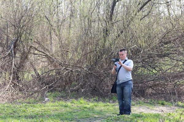 Akıllı telefondan videoya kaydolan genç bir adam. Düzgün çekim ler elde etmek için gimbal kullanır. Ekrana dokunarak kaydı kontrol eder. — Stok fotoğraf