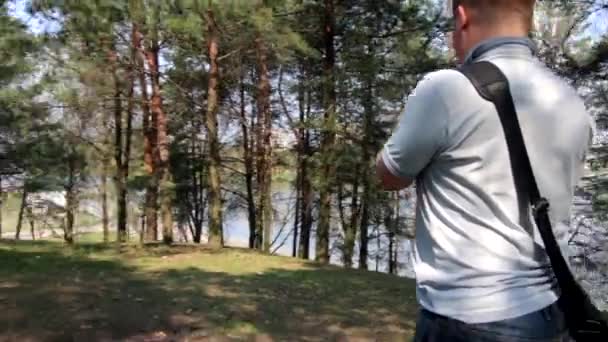 一个年轻人在春天公园的智能手机上拍摄视频 使用电子云台 — 图库视频影像