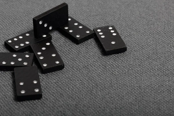 Domino knuckles on a surface covered with a coarse gray cloth.