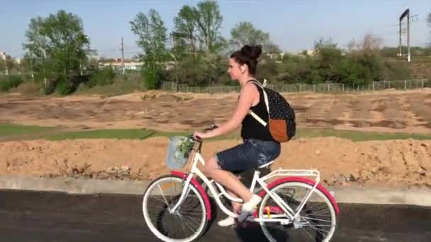 Rapariga Anda Bicicleta Numa Estrada Asfalto Atrás Sua Mochila Cesto — Vídeo de Stock