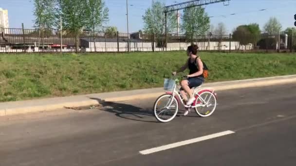 Chica Monta Una Bicicleta Camino Asfalto Detrás Mochila Una Cesta — Vídeos de Stock